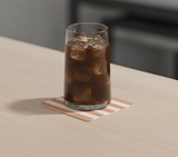 Vaso con hielo sobre posavasos de cuero reciclado a rayas, protector de mesa elegante para hogar y hostelería.